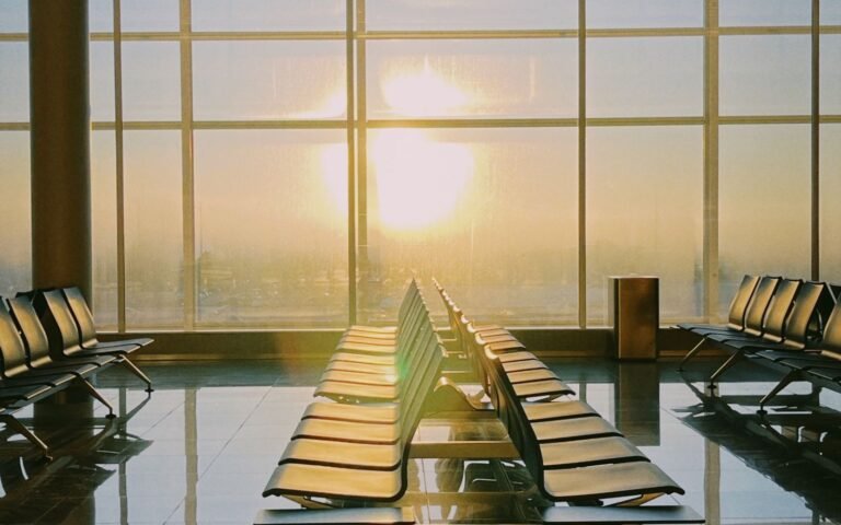 Airport seating by wide windows at sunset